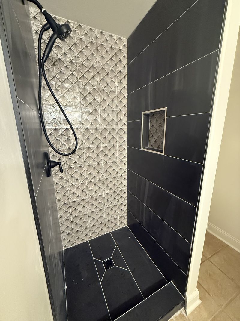Custom tiled shower with art deco feature wall and black tile surround, bathroom renovation in Delaware County PA